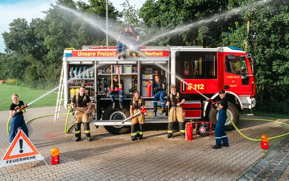 Gruppenbild der Jugendfeuerwehr (Jugendliche und Jugendwarte) vor dem Löschfahrzeug